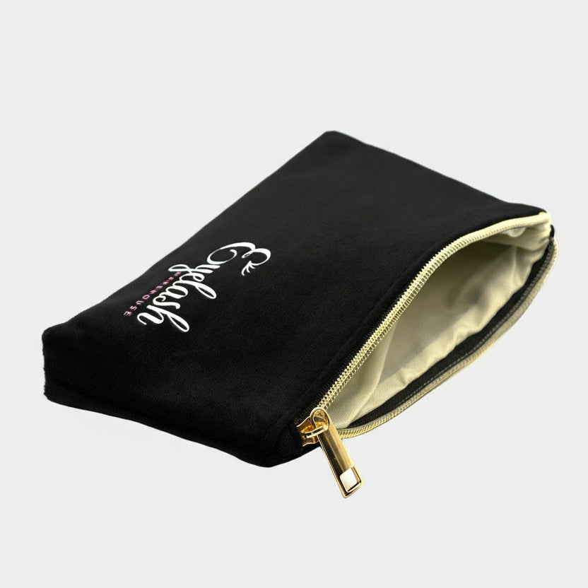 Black pouch with gold zipper and white text on a white background
