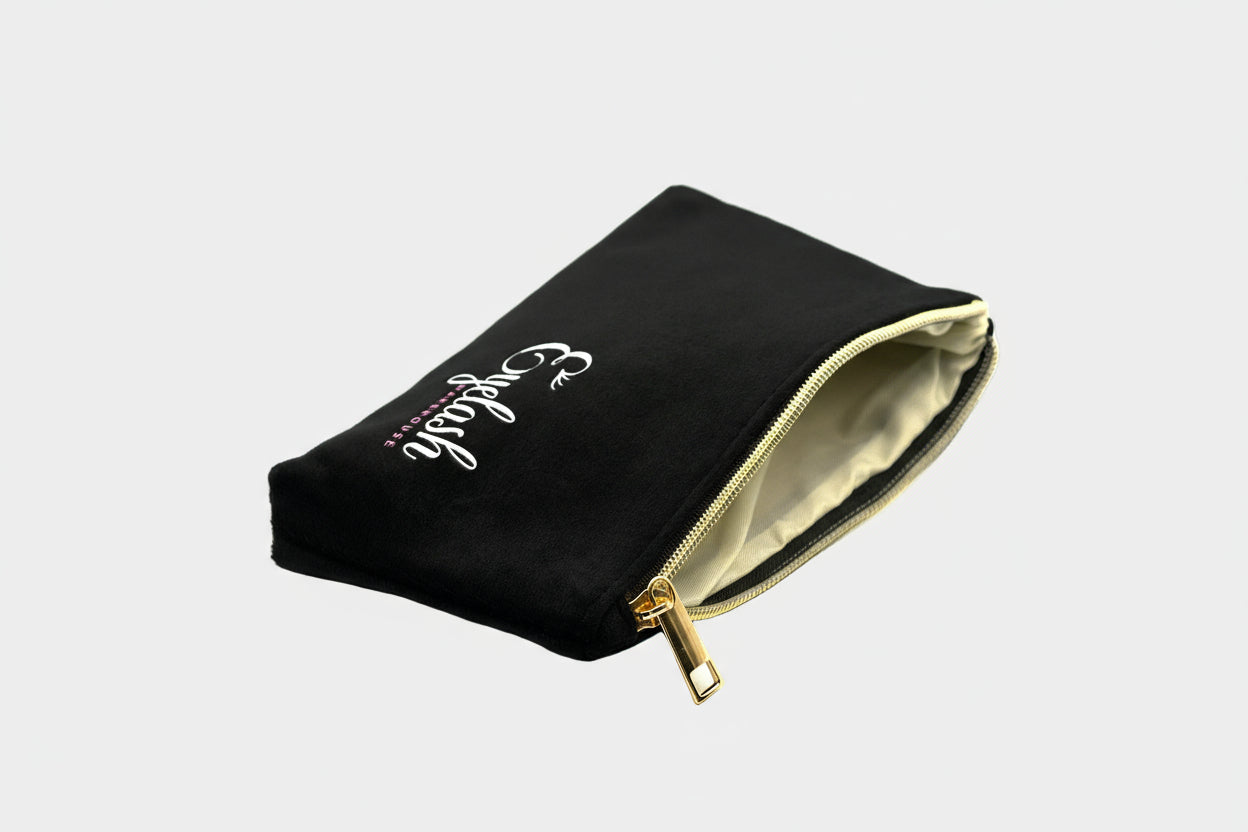 Black pouch with gold zipper and white text on a white background