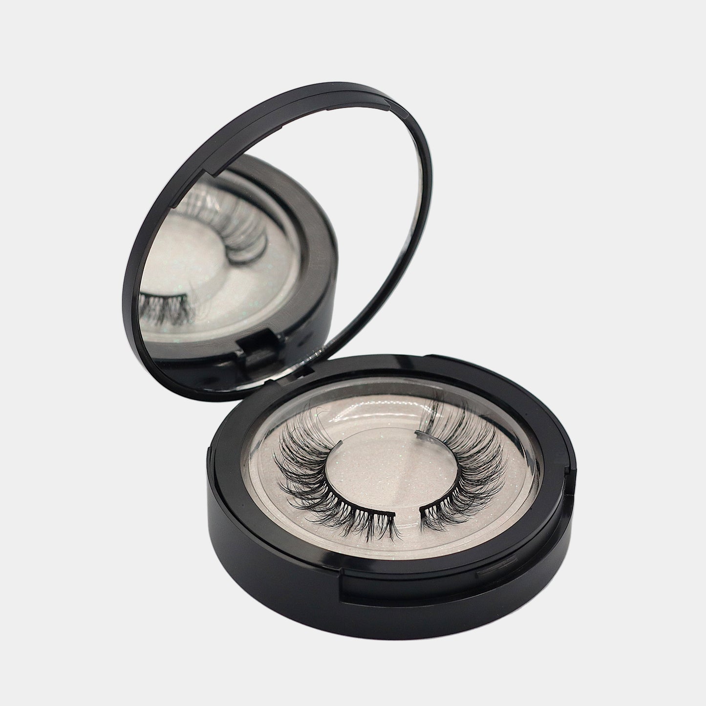 Mirrored strip lash compact open showing top tray with lashes