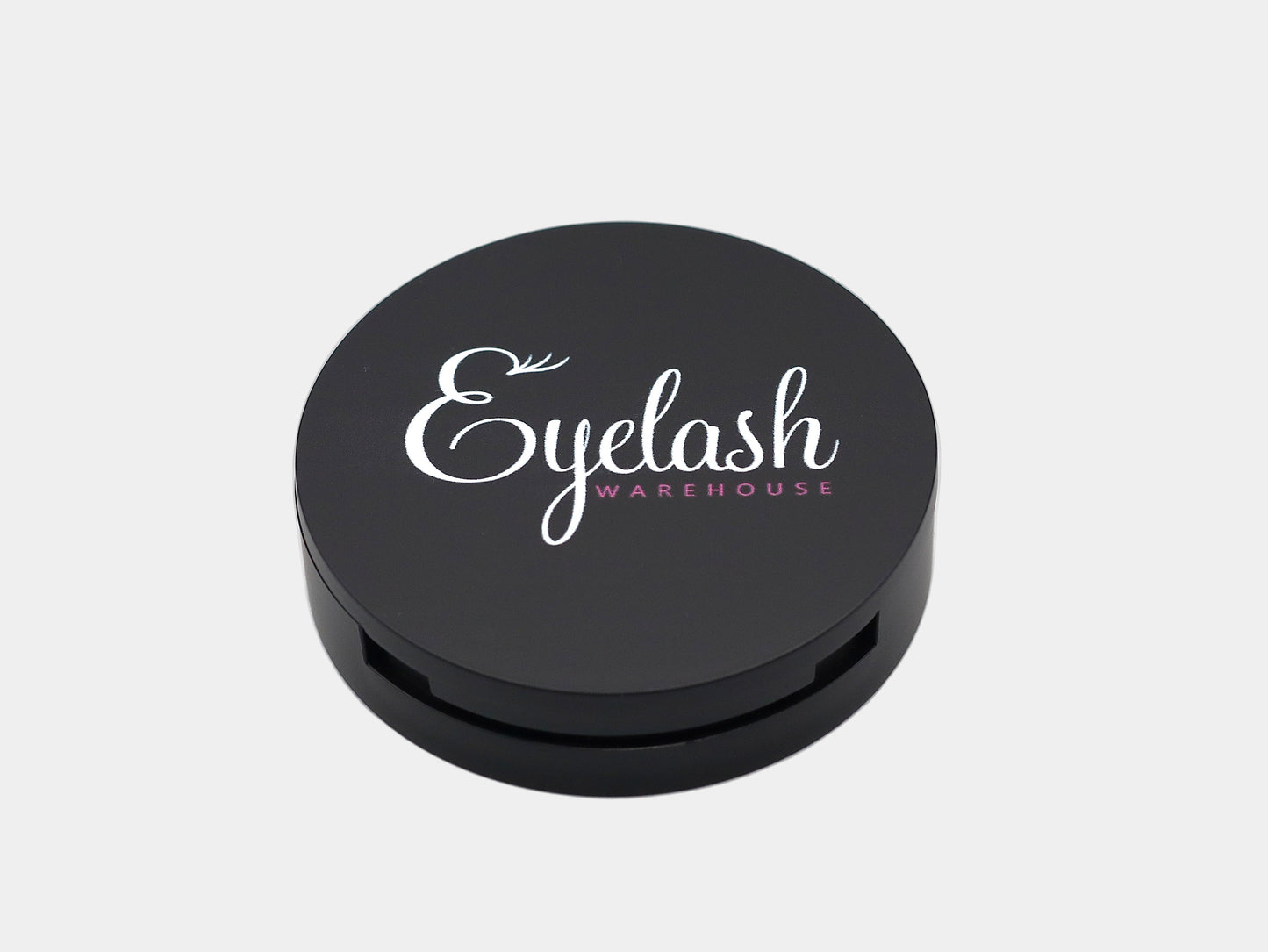 Black round strip lash container with 'Eyelash Warehouse' logo on a light gray background
