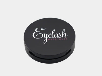 Black round strip lash container with 'Eyelash Warehouse' logo on a light gray background